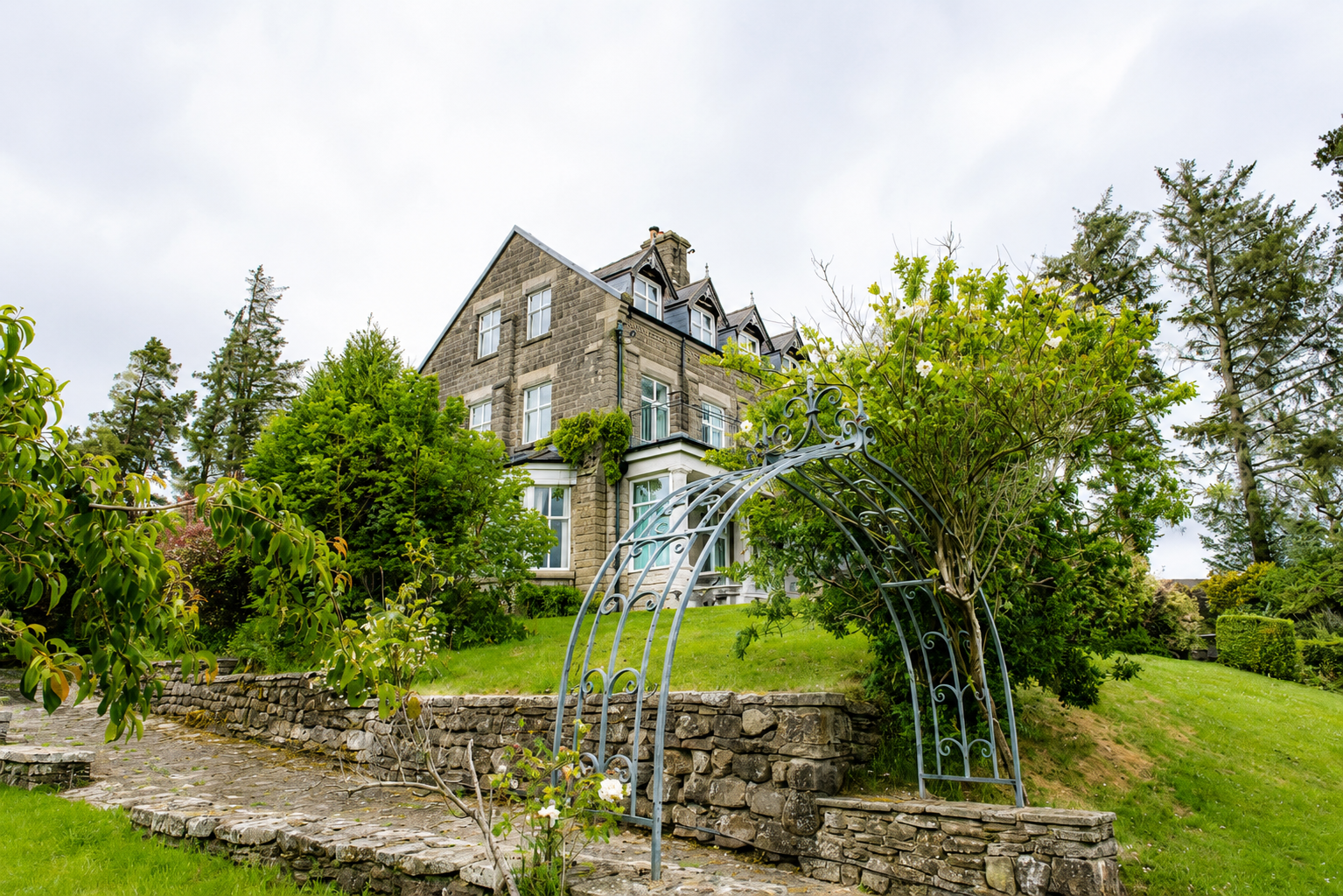Heather Brae exterior with garden arch and stone house