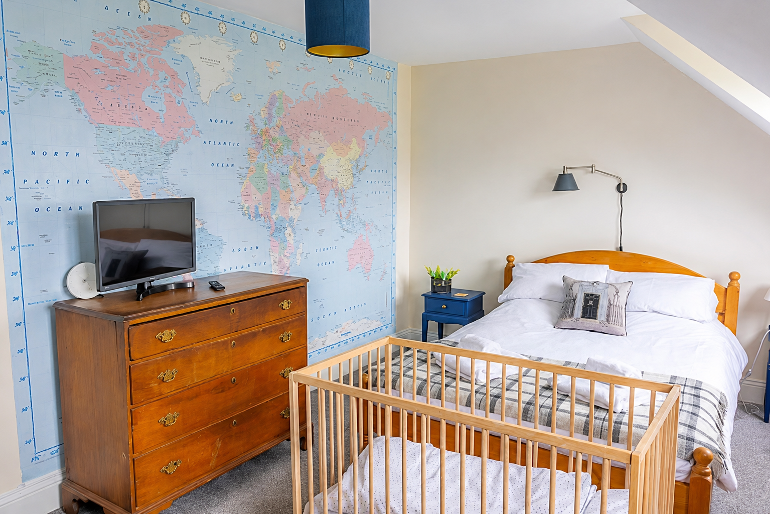 Family bedroom at Heather Brae with world map wallpaper and travel cot