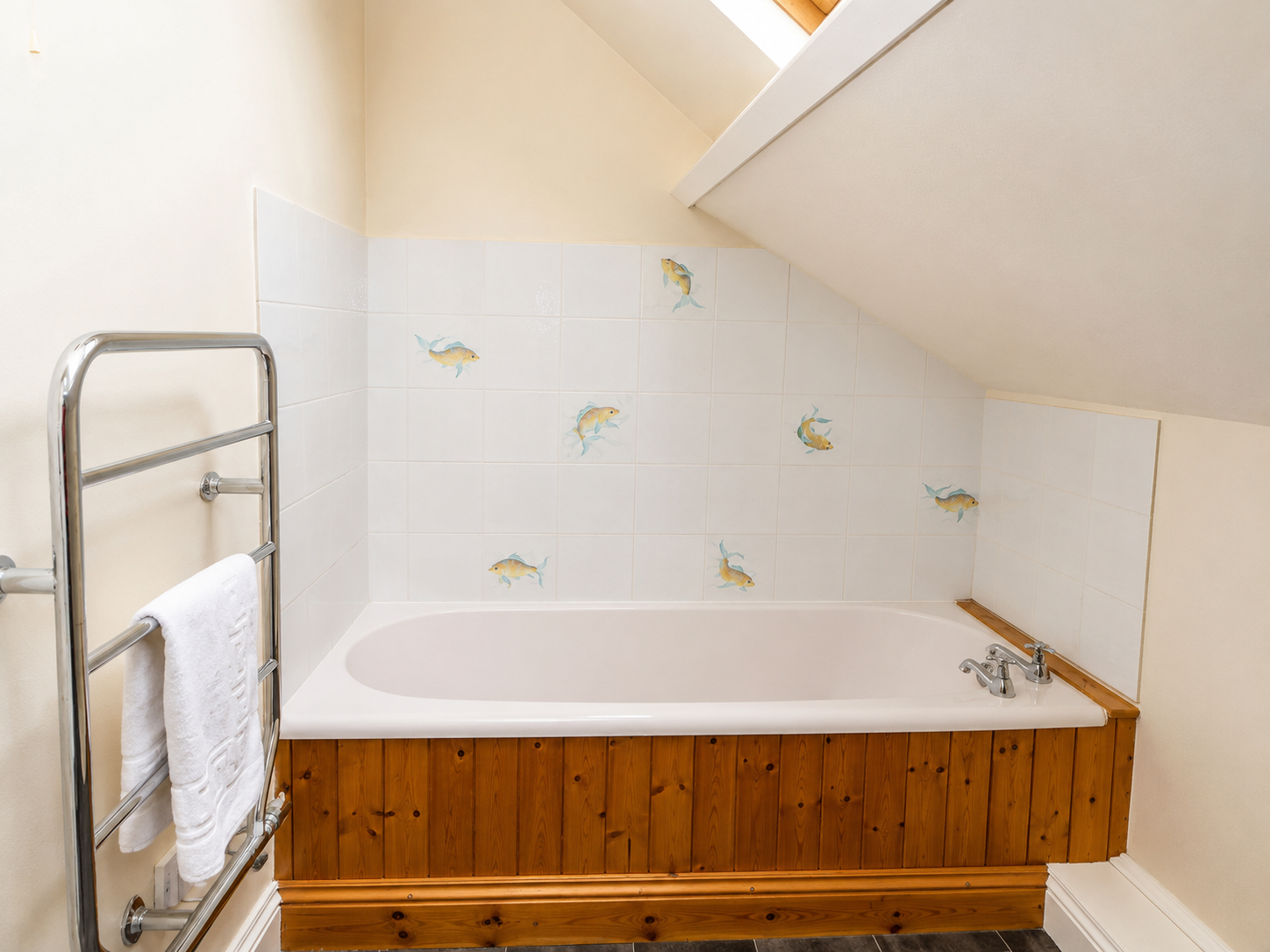 Family bathroom with bath and fish-motif tiling at Heather Brae