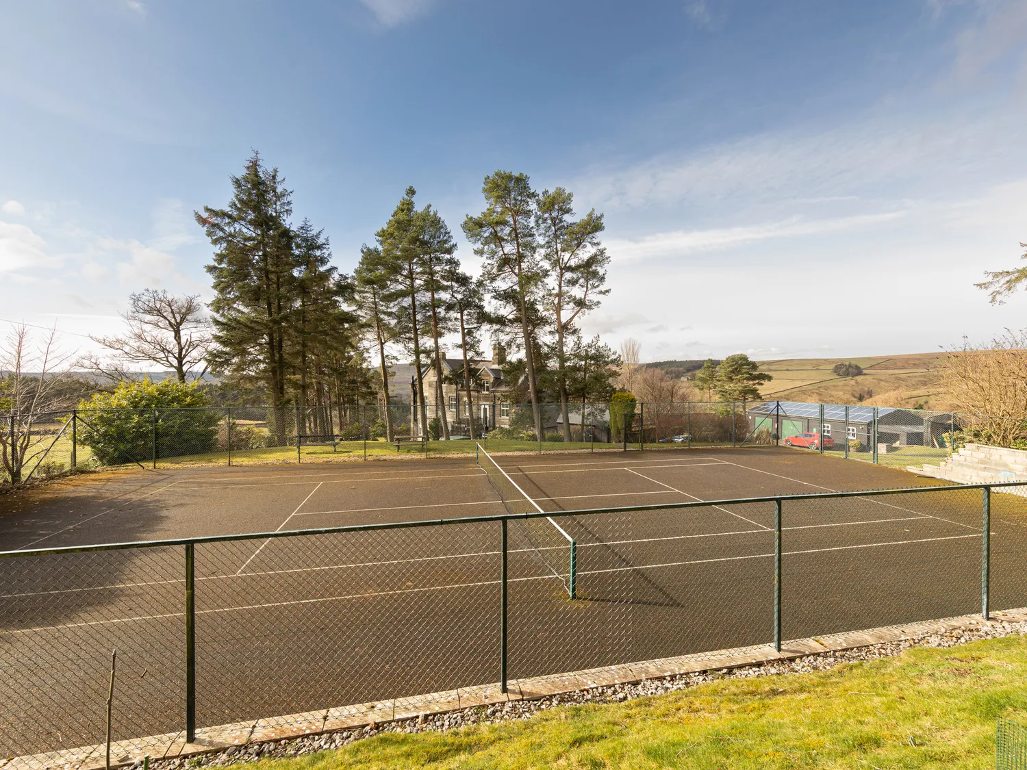 Tennis court with house and moorland view at Heather Brae