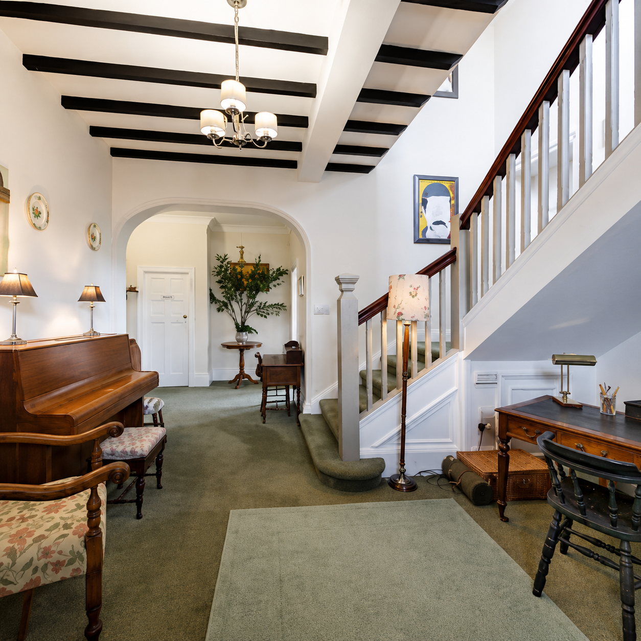 Grand entrance hall at Heather Brae with piano, staircase, beamed ceiling and original features